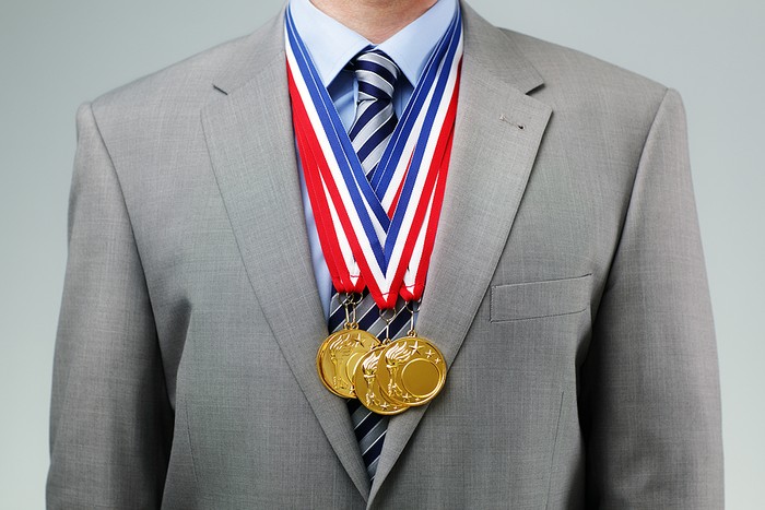 Man in Suit Wearing Gold Medals