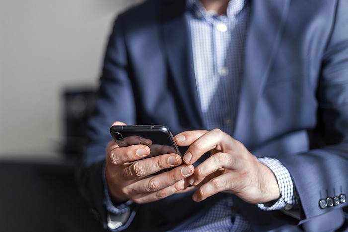 Man in Blue Suit Using Smartphone