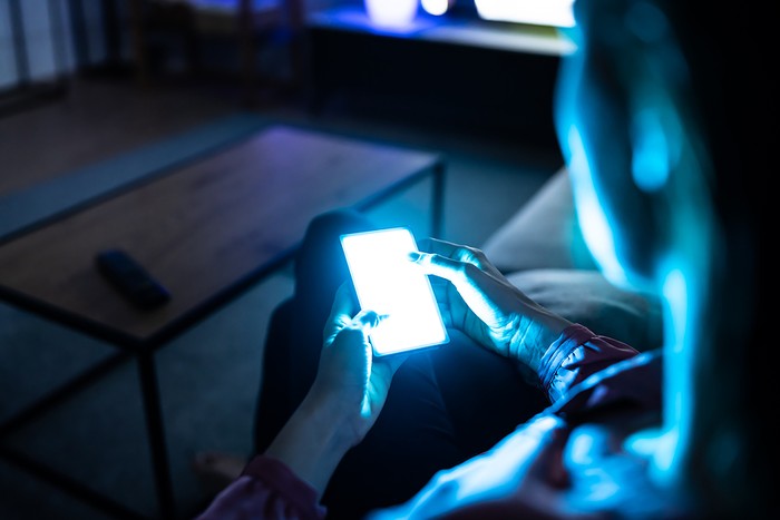 Woman Using Smartphone in Dark Room