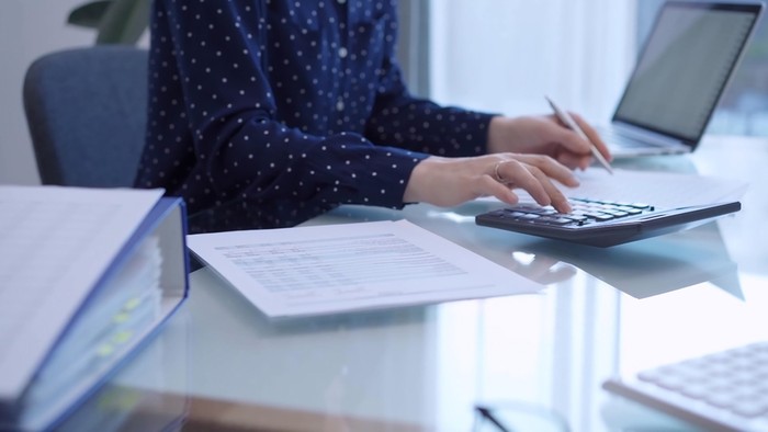Accountant Using Calculator at Desk