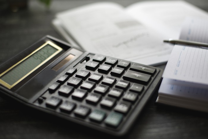 Black Calculator and Calendar on Desk
