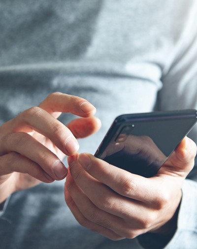 Man Wearing Grey Holding Phone