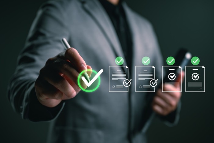 Businessman in Grey Suit with Digital Checklists