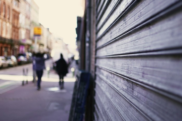 Closed Shop Shutters on Blurred High Street