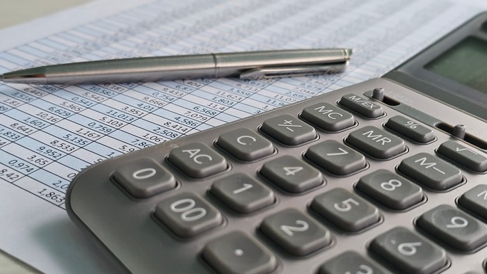 Grey Calculator with Silver Pen and Paperwork