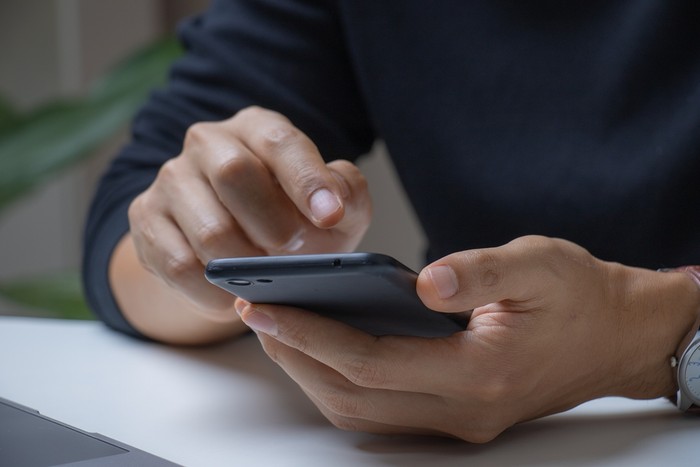 Man with Navy Jumper Using Phone