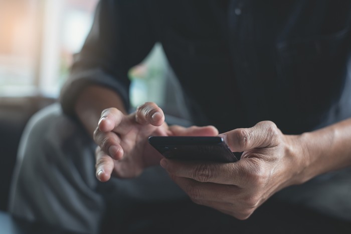 Sitting Man Holding Phone